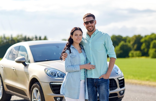 transport, voyage sur la route, voyage, concept de famille et de personnes - homme et femme heureux étreignant à la voiture