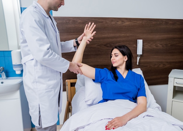 Traumatologue examinant les mains des patients dans un hôpital moderne