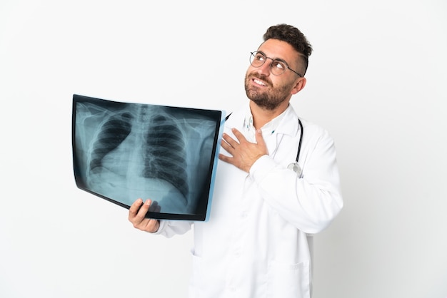 Traumatologue professionnel isolé sur un mur blanc en regardant en souriant