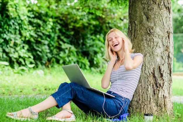 Travail dans le parc d'été. Raisons pour lesquelles vous devriez emmener votre travail à l'extérieur. La nature est essentielle au bien-être et à la capacité d'être productif. Fille travaille avec ordinateur portable dans le parc. Déjeuner détente ou pause café.