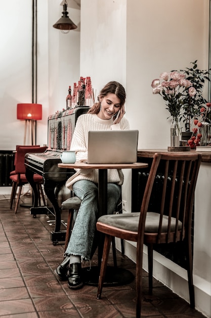 Travail à distance. La femme se sent à l'aise lorsqu'elle travaille à distance depuis un café