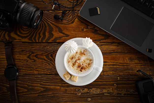 Travail à domicile bureau avec ordinateur portable et appareil photo tasse à café sur table en bois vue de dessus à plat