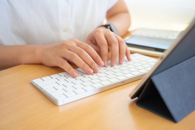 Travail à domicile jeune pigiste ou homme d'affaires travaillant au bureau à domicile avec tablette smartphone.