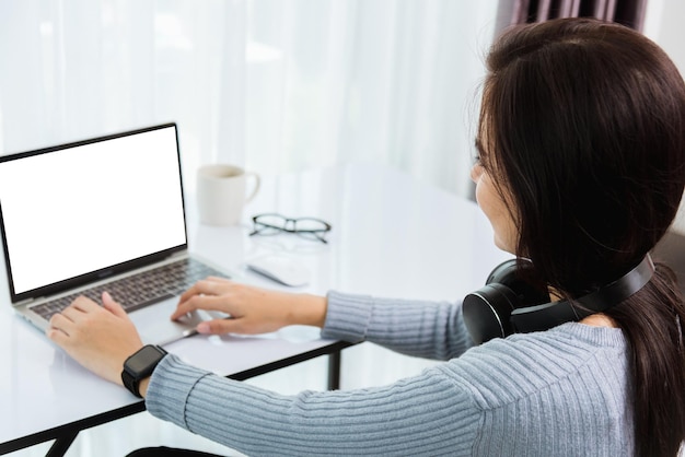 Travail à domicile, retour d'une jeune femme d'affaires asiatique par vidéoconférence ou réunion facetime en ligne sur un ordinateur portable avant met en quarantaine la maladie coronavirus ou COVID-19 au bureau à domicile, Focus sur un ordinateur portable