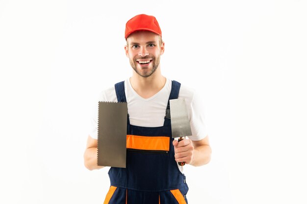 Travail du plâtre à la spatule. l'homme plâtrier joyeux tient la truelle.