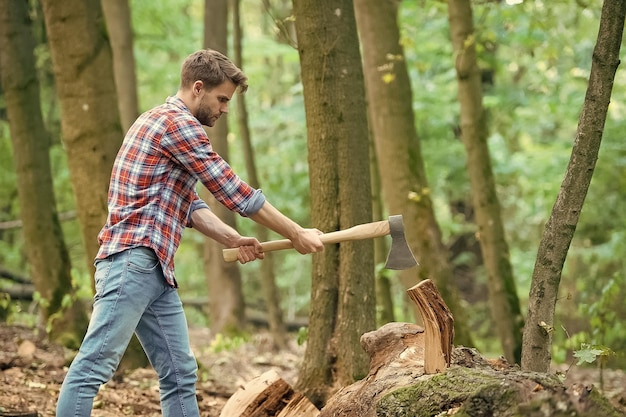 Travail dur du bois de chauffage au camping camping et randonnée activité de plein air homme fort avec hache bûcheron ranch homme porter une hache mec sexy porter une chemise dans la forêt puissance et énergie masculines