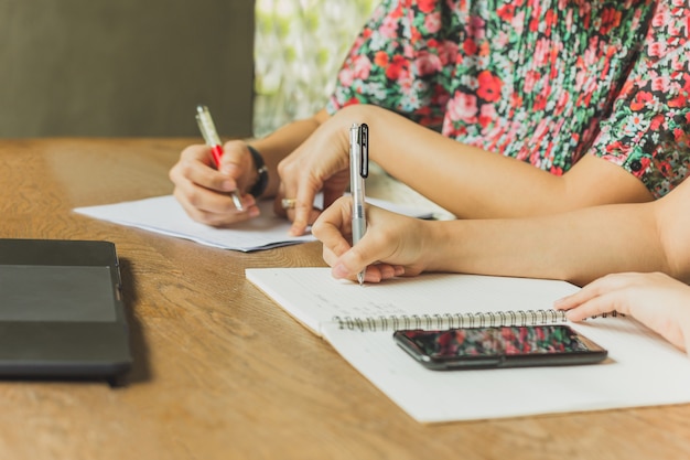 Travail d'équipe d'affaires assis à la table au café et écrit sur les documents.