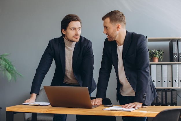 Travail d'équipe d'affaires deux hommes d'affaires travaillant ensemble sur un ordinateur portable