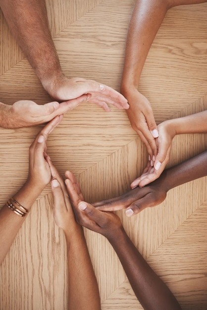 Photo travail d'équipe sur la diversité et mains créatives en synergie des employés travaillant ensemble en collaboration au travail table groupe de personnes main dans le cercle unité pour l'aide à l'accord et équipe pour la communauté