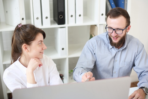 Travail d'équipe homme et femme au bureau. Regardez l'écran de l'ordinateur