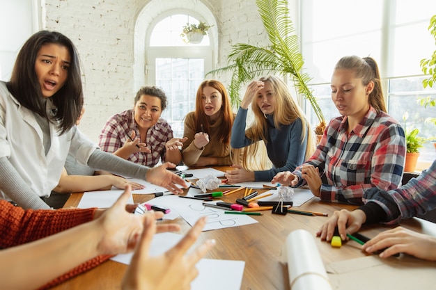 Travail en équipe. Des jeunes discutent des droits des femmes et de l'égalité au bureau. Des femmes d'affaires ou des employés de bureau de race blanche se sont réunis à propos de problèmes sur le lieu de travail, de pression masculine et de harcèlement.