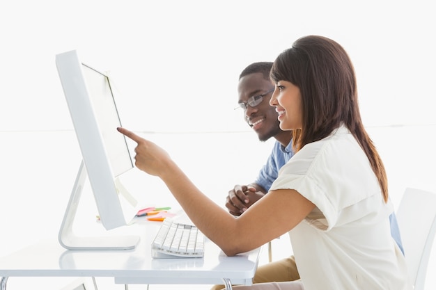 Travail d&#39;équipe joyeuse à l&#39;aide d&#39;un moniteur d&#39;ordinateur