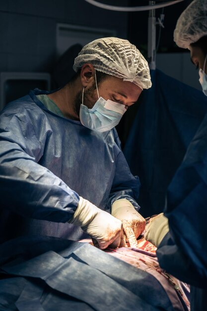 Photo travail d'équipe avec masque un groupe de professionnels de la médecine dans une opération