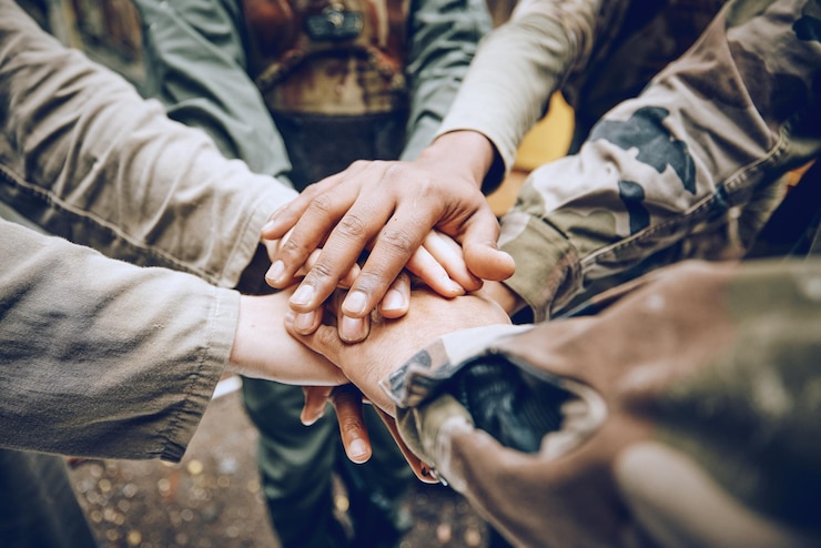Photo travail d'équipe militaire ou mains dans un caucus pour une stratégie de mission ou une motivation sur un champ de bataille de paintball objectifs collaboration ou personnes de l'armée avec soutien dans un partenariat ou un groupe de soldats prêts