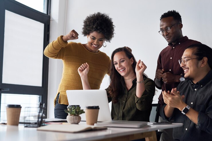 Photo travail d'équipe sur ordinateur portable et réunion au bureau pour célébrer le projet et le groupe d'affaires heureux diversité d'hommes et de femmes sur le lieu de travail ou dans l'agence avec la technologie pour la réalisation en ligne et l'examen le matin
