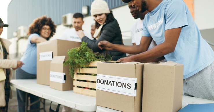 Photo travail d'équipe personnes bénévoles et boîtes de nourriture sur la table pour un événement de charité avec soin gentillesse et confiance don communautaire hommes et femmes dans les ong avec distribution de paquets d'épicerie dans un projet sans but lucratif