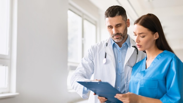 Travail d'équipe de soins de santé médecin et assistant examinant les antécédents médicaux des patients en discutant