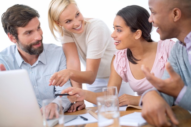 Le travail est amusant pour cette équipe Photo d'un groupe de gens d'affaires au milieu d'une discussion