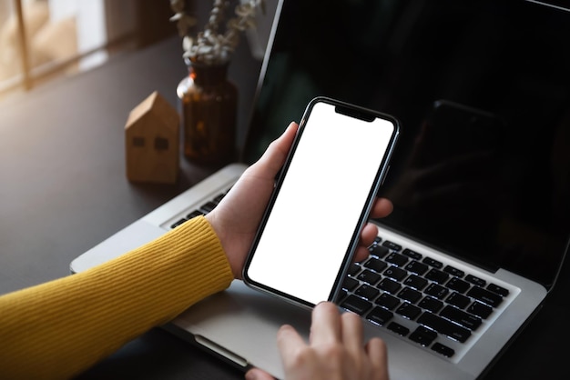 Travail féminin à l'écran du smartphone à l'aide d'un téléphone avec un fond blanc pour la publicité des informations de recherche d'entreprise de contact sur le bureau dans la conception de marketing de café