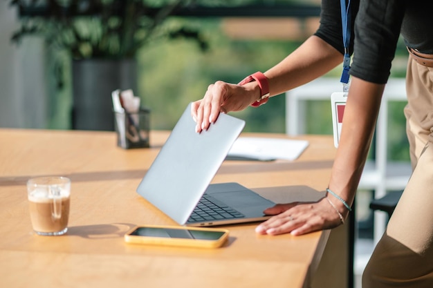 Travail fini. Femme d'affaires fermant son lapop à la fin de la journée de travail