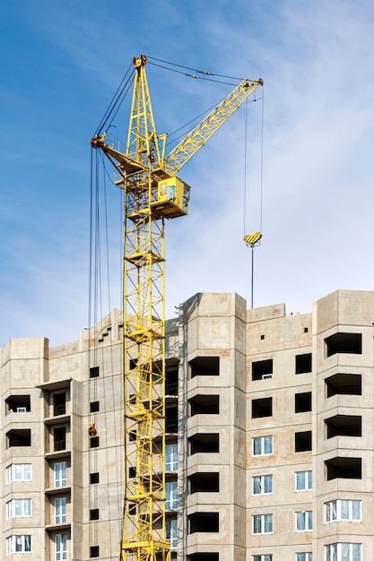 Le travail d'une grue à tour lors de la construction d'une maison à panneaux en béton armé