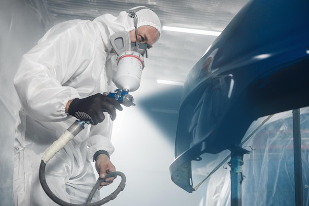 Travail de peinture de voiture par un travailleur professionnel Procédure de peinture de voiture dans un garage de peinure de carrosserie de service de voiture