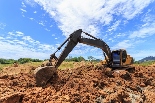 Travail de plein air: Excavatrice creusant pour déplacer le sol