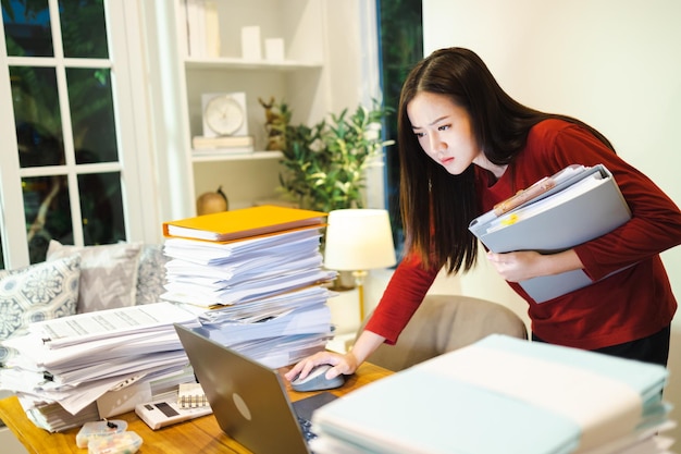 Travail urgent Asain femme debout au bureau à la maison la nuit Concept de personnes bourreau de travail