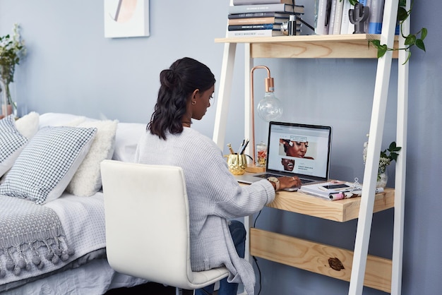 Travaillant sur sa page d'accueil pour son blog Photo recadrée d'une jolie jeune femme travaillant à la maison