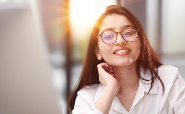 travaillant sur son ordinateur ou son ordinateur portable au bureau. Elle semble satisfaite de son travail et de son employeur.