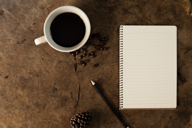 Travailler avec des cahiers et des tasses à café sur des planchers en bois.