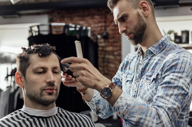 Travailler dans le salon de coiffure homme coiffeur