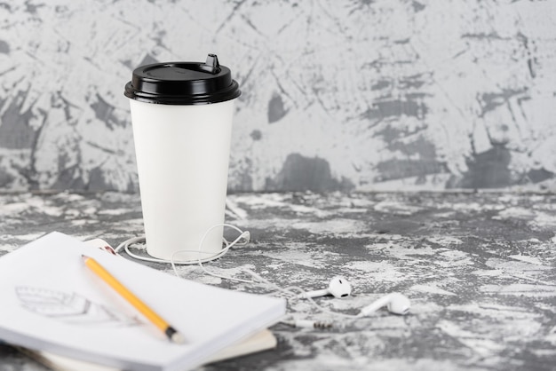 Travailler en déplacement. Tasse à café et bloc-notes sur table en pierre grise. Copiez l'espace.