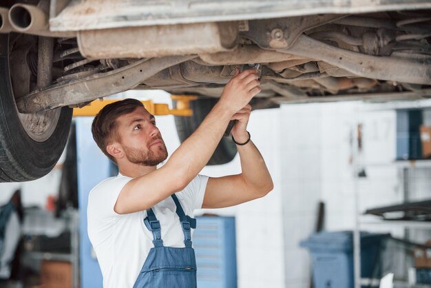 Travailler sur les détails. Employé dans l'uniforme de couleur bleue ont un emploi dans le salon de l'automobile