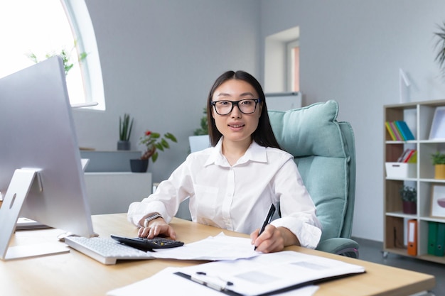 Travailler avec des documents portrait d'une belle jeune femme d'affaires comptable asiatique travaille avec