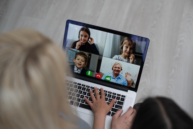 Travailler à domicile avec un enfant. Heureuse mère et fille faisant des achats en ligne, utilisant un ordinateur portable ensemble. Femme étreignant l'enfant. Lieu de travail indépendant à la table de la cuisine. Entreprise féminine, communication virtuelle.