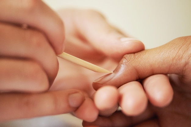 Travailler la magie sur ses ongles Photo recadrée d'une femme se faisant manucurer