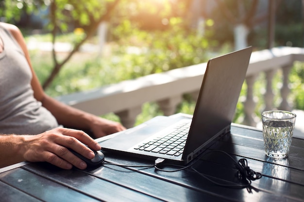 Travailler sur un ordinateur portable dans la cour extérieure, les mains des hommes se rapprochent du bureau à domicile, du travail à distance, à l'aide du clavier et de la souris, détendez-vous