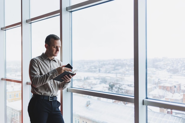 Travailler avec des papiers Homme entrepreneur sérieux travaillant au bureau seul lisant un document sur papier en pensant aux termes Jeune homme concentré faisant de la paperasse accord d'édition tex