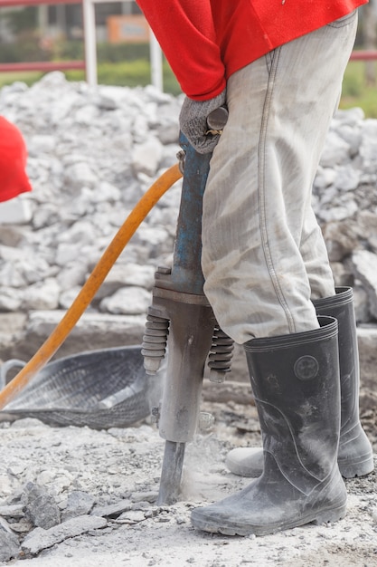 travailleur à l&#39;aide de ciment de forage de construction sur le sol