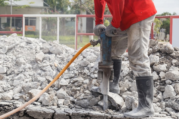 travailleur à l&#39;aide de ciment de forage de construction sur le sol