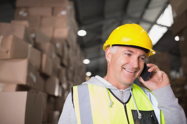 Travailleur à l&#39;aide de téléphone portable dans l&#39;entrepôt