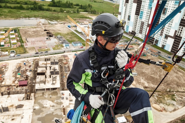 Travailleur de l'alpinisme industriel en uniforme avec talkie-walkie