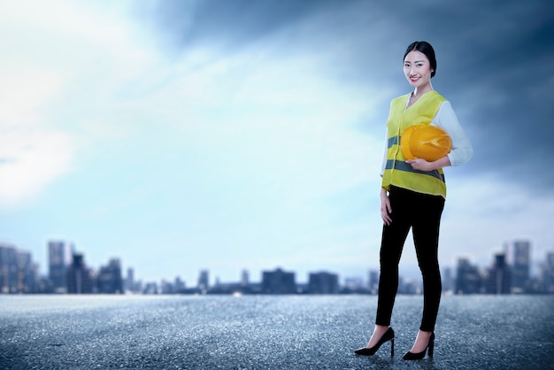 Travailleur asiatique femme tenant un casque jaune debout