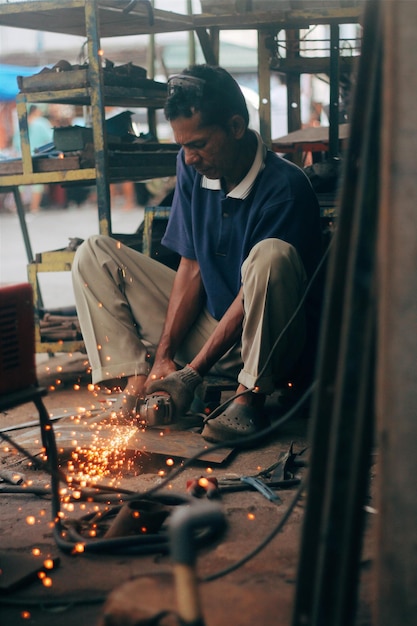 Photo travailleur d'atelier coupant des plaques de fer avec une machine-outil de coupe