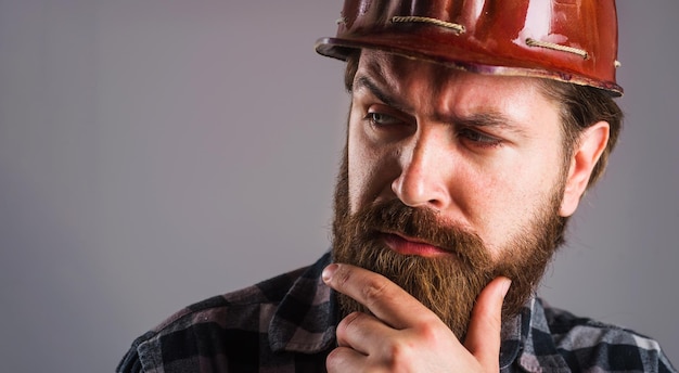 Travailleur en casque constructeur barbu dans un casque de protection portrait en gros plan d'un ingénieur ou d'un architecte fatigué