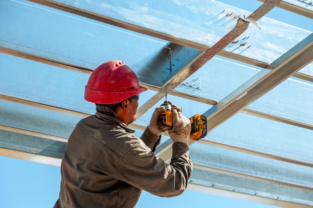 Photo travailleur avec un casque rouge sur le chantier