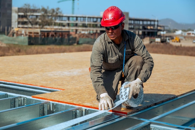 Photo travailleur avec un casque rouge sur le chantier