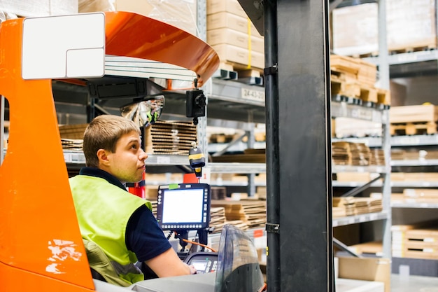 Photo un travailleur conduisant un chariot élévateur dans une usine