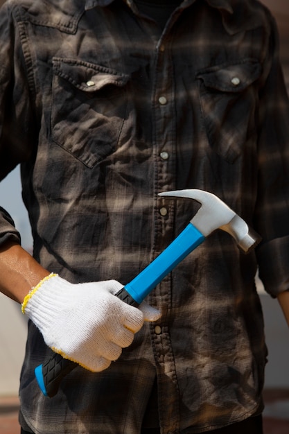 Photo travailleur de la construction à l'aide d'un marteau sur le chantier